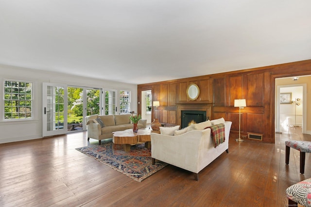 167 Skunk Ln, Wilton, CT 06897 - living area featuring dark wood finished floors, a warm lit fireplace, baseboards, and wood walls