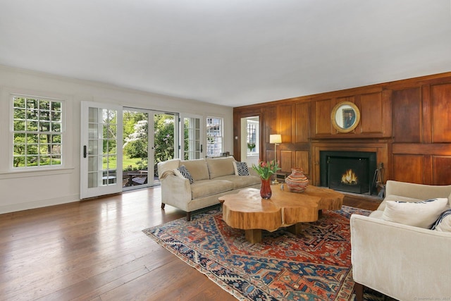 167 Skunk Ln, Wilton, CT 06897 - living area featuring a lit fireplace, wood finished floors, baseboards, crown molding, and wooden walls