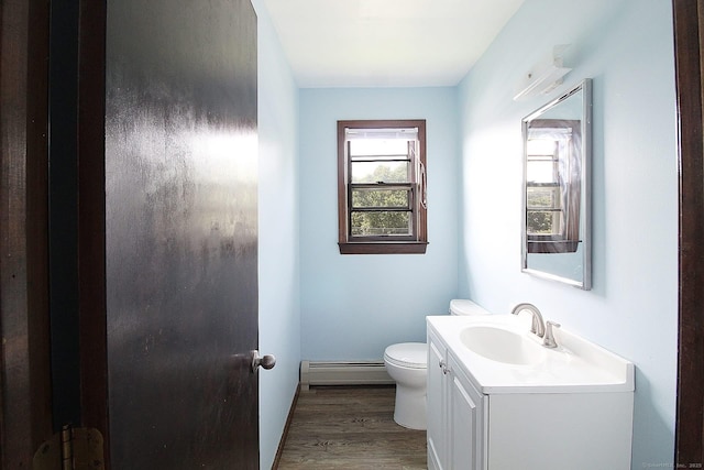 bathroom featuring toilet, wood finished floors, vanity, and a baseboard radiator