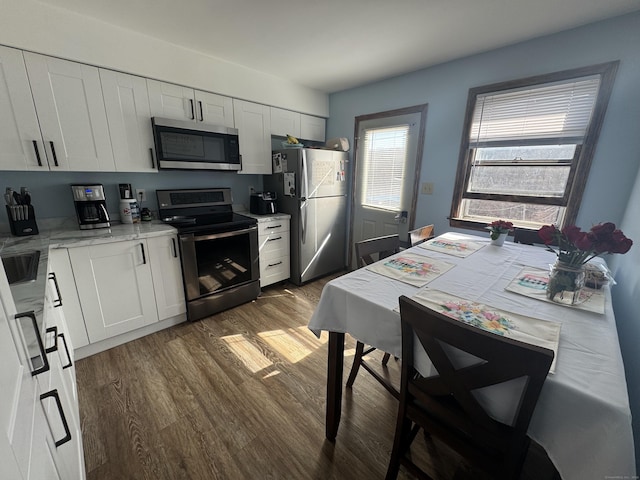 kitchen featuring white cabinetry, appliances with stainless steel finishes, and dark wood-type flooring