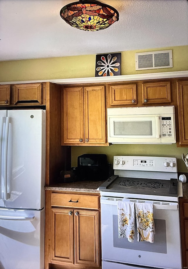 15 Pilgrim Hbr Unit A, Wallingford, CT 06492 - kitchen with white appliances, brown cabinetry, and dark countertops