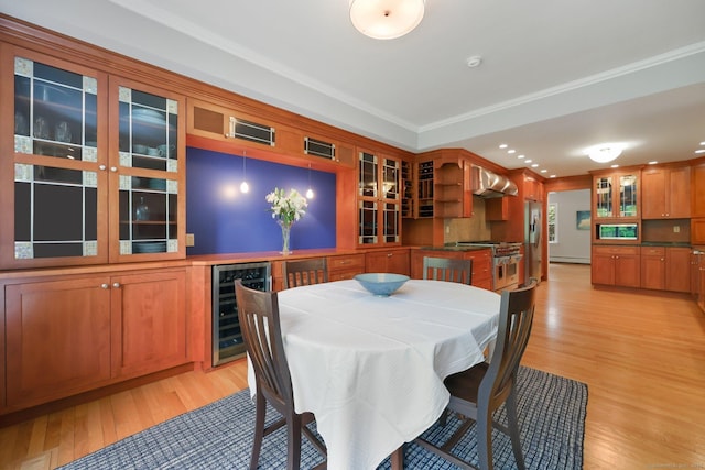 dining space featuring beverage cooler, light wood-style floors, ornamental molding, and recessed lighting