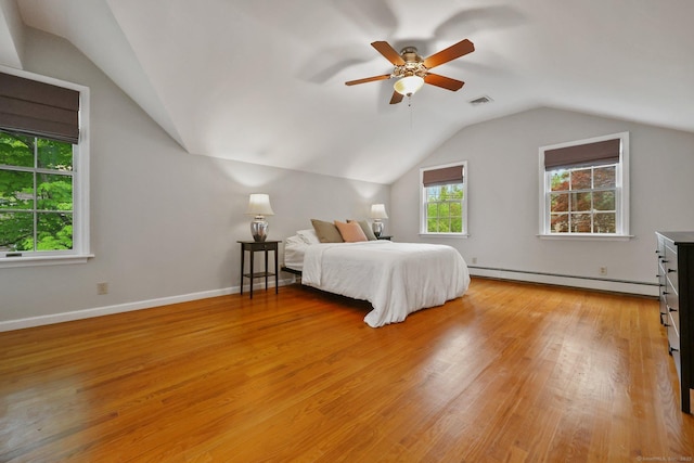 bedroom featuring a baseboard heating unit, vaulted ceiling, light wood finished floors, a ceiling fan, and baseboards