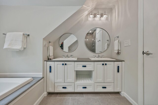 bathroom featuring tile patterned flooring, baseboards, double vanity, and a tub to relax in