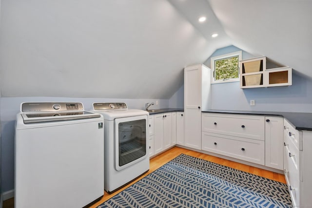 washroom featuring separate washer and dryer, light wood-style flooring, cabinet space, and recessed lighting