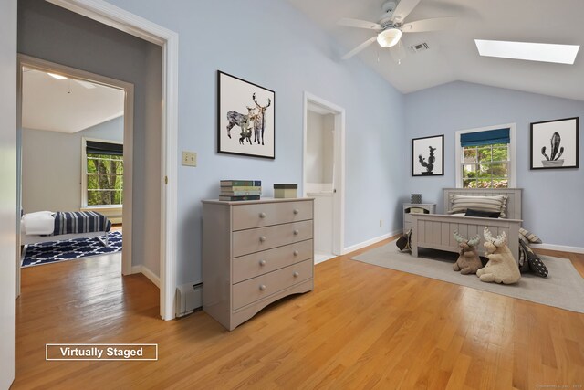 sitting room with plenty of natural light, lofted ceiling, light wood finished floors, and a skylight