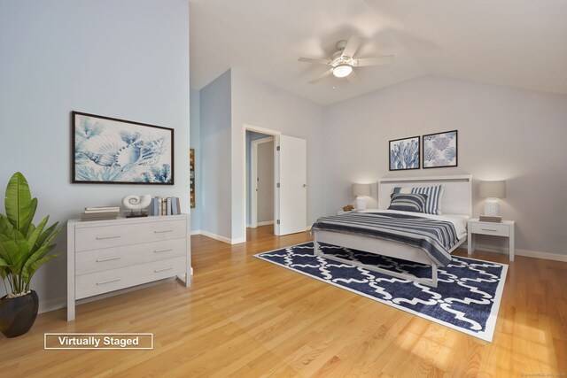 bedroom featuring wood finished floors, lofted ceiling, baseboards, and ceiling fan
