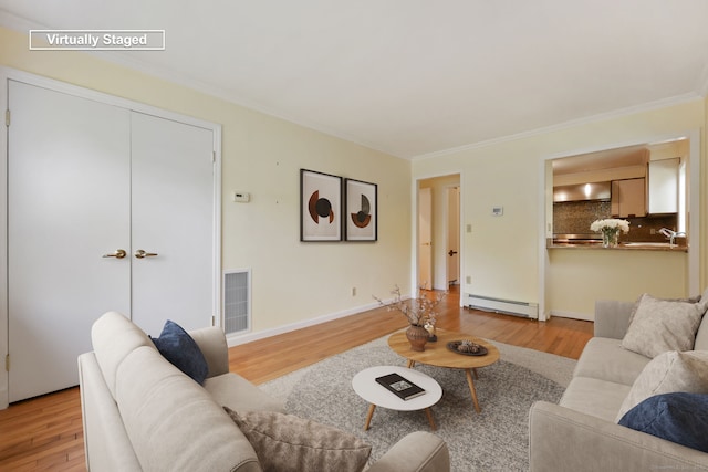 living room with baseboard heating, light wood-style flooring, and crown molding