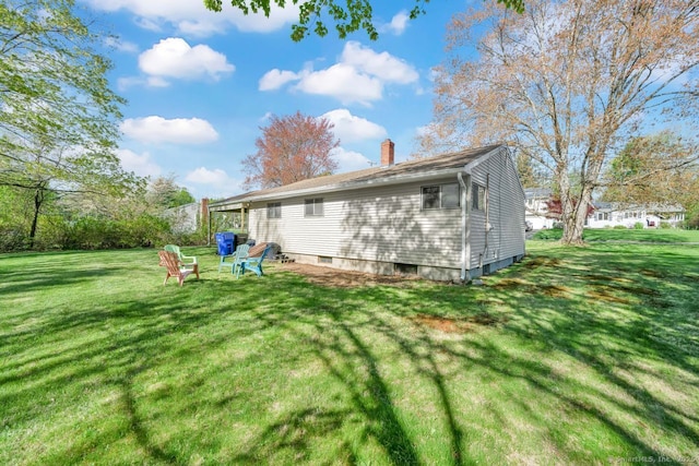 back of house with a lawn and a chimney