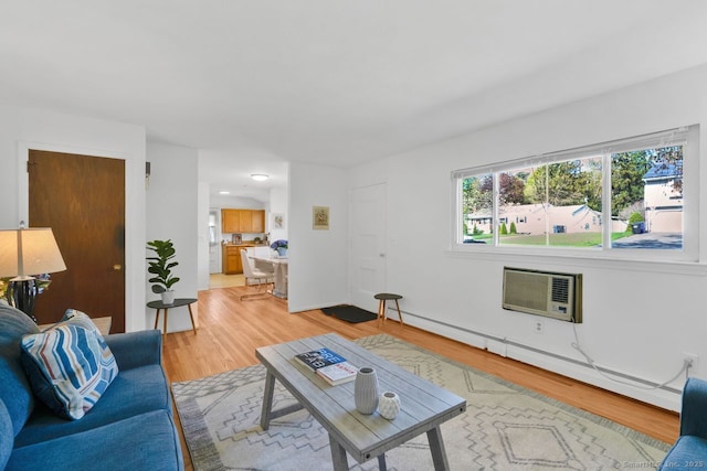 living area with light wood-style floors, baseboards, a wall mounted AC, and a baseboard heating unit