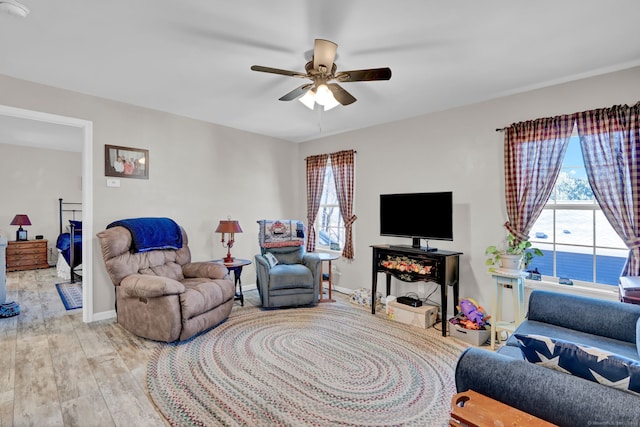 living room with baseboards, wood finished floors, and a ceiling fan