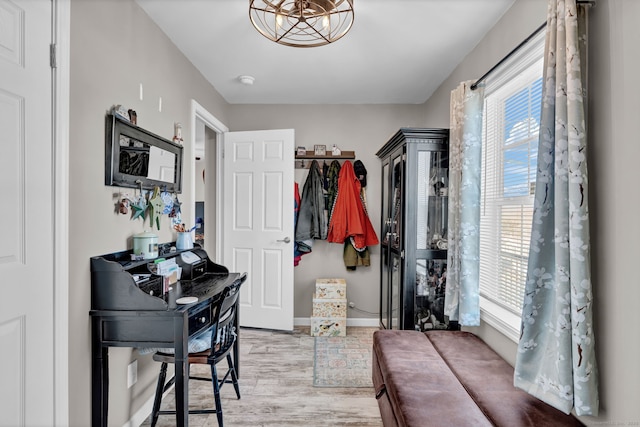 interior space featuring a notable chandelier, wood finished floors, and baseboards