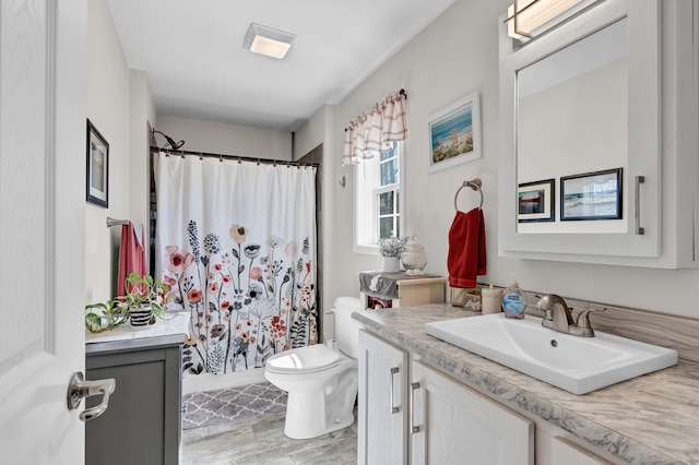 bathroom with vanity, toilet, and curtained shower