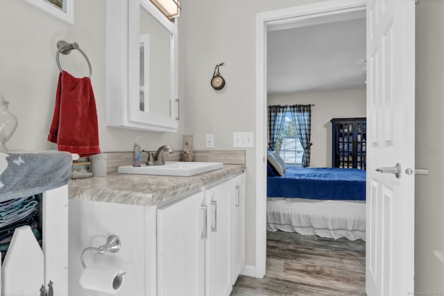 ensuite bathroom featuring wood finished floors, ensuite bathroom, and vanity