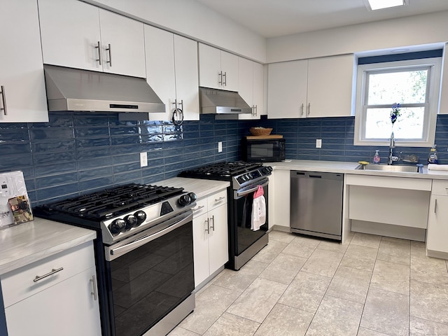 kitchen featuring appliances with stainless steel finishes, a sink, light countertops, and under cabinet range hood