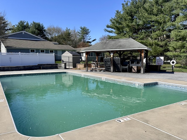 community pool featuring fence, a gazebo, and a patio