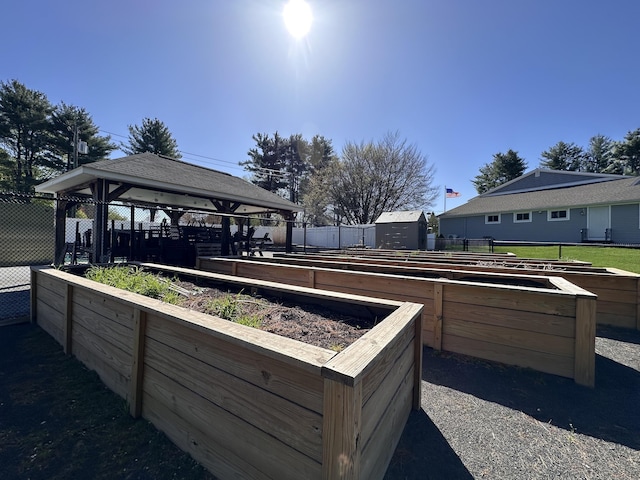 view of patio / terrace with fence, a gazebo, and a garden