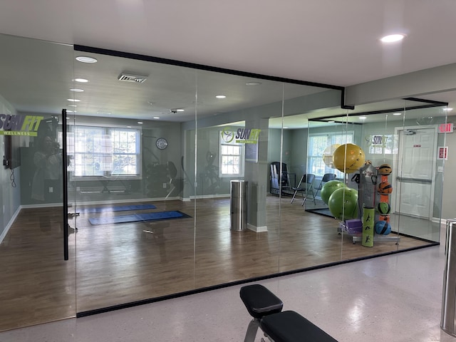 workout area featuring baseboards, recessed lighting, visible vents, and plenty of natural light