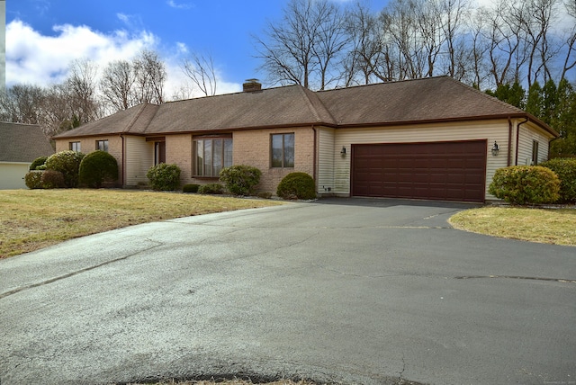 single story home with a shingled roof, a garage, driveway, and a chimney