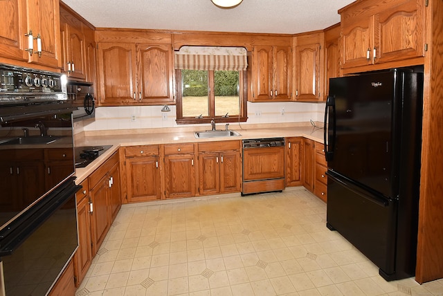 kitchen with brown cabinetry, light countertops, a sink, and black appliances