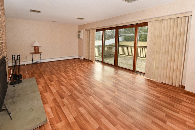 unfurnished living room featuring a fireplace, visible vents, baseboards, and wood finished floors