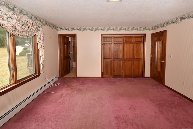unfurnished bedroom with a textured ceiling, a closet, a baseboard heating unit, and carpet floors