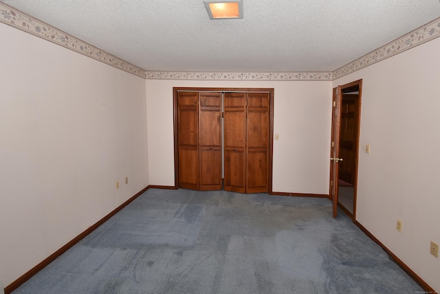 unfurnished bedroom with a textured ceiling, a closet, baseboards, and carpet floors