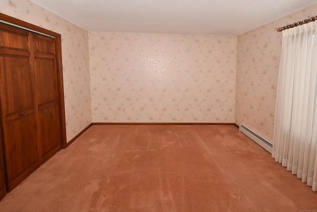 unfurnished bedroom with a textured ceiling, light colored carpet, a baseboard heating unit, wallpapered walls, and baseboards