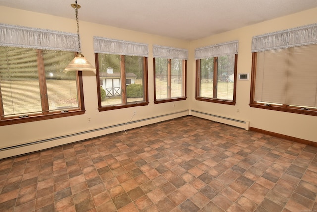 unfurnished sunroom featuring stone finish floor, a baseboard heating unit, and baseboards