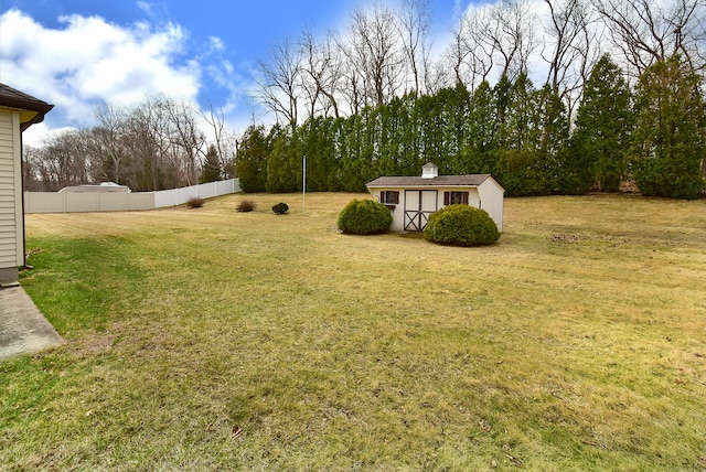 view of yard with an outbuilding, fence, and a shed