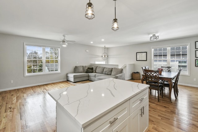 10 Bidwell Ter, Middletown, CT 06457 - kitchen with open floor plan, light wood-style floors, white cabinetry, ceiling fan, and hanging light fixtures