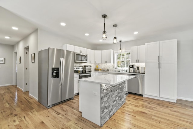 10 Bidwell Ter, Middletown, CT 06457 - kitchen featuring hanging light fixtures, decorative backsplash, light wood-type flooring, stainless steel appliances, and white cabinetry