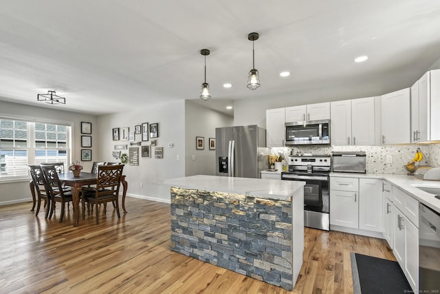 10 Bidwell Ter, Middletown, CT 06457 - kitchen featuring light countertops, baseboards, decorative backsplash, light wood-style flooring, and appliances with stainless steel finishes