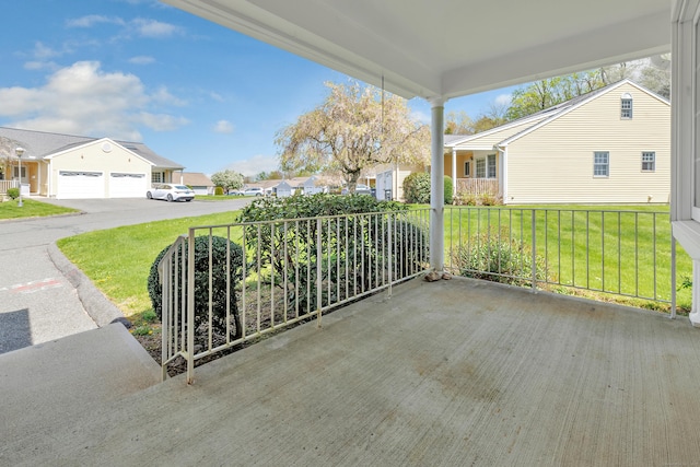 view of patio / terrace with a porch, concrete driveway, and a residential view