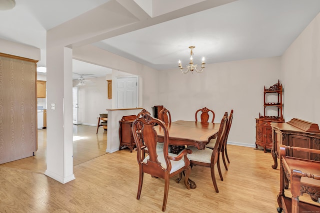 dining area featuring baseboards, light wood-style floors, and ceiling fan with notable chandelier