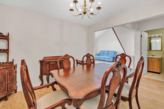 dining space with light wood finished floors and a notable chandelier