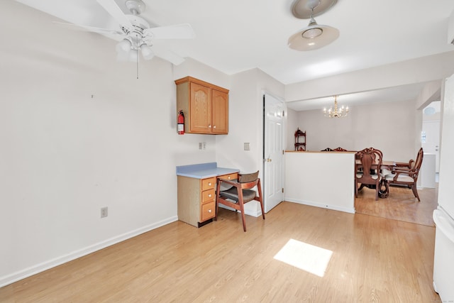 kitchen with brown cabinetry, ceiling fan with notable chandelier, light wood finished floors, light countertops, and baseboards