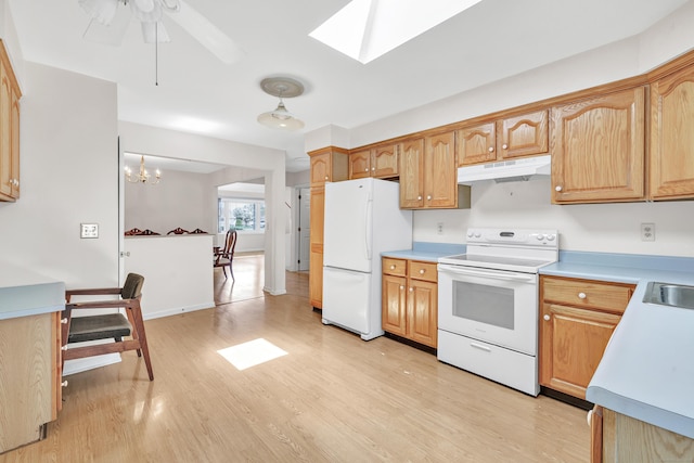 kitchen with white appliances, ceiling fan with notable chandelier, light wood-type flooring, under cabinet range hood, and light countertops