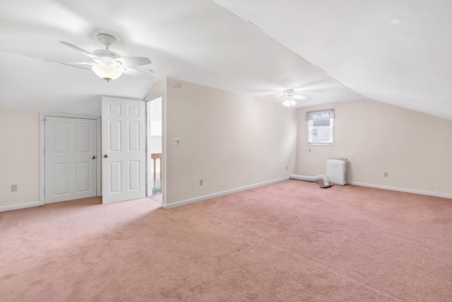 additional living space with vaulted ceiling, ceiling fan, and light colored carpet