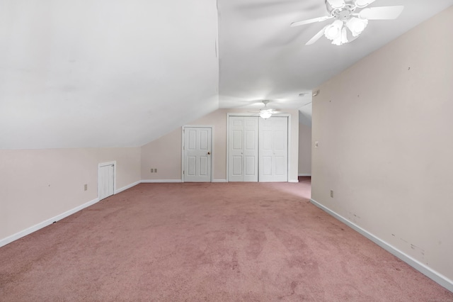 additional living space featuring baseboards, light carpet, lofted ceiling, and a ceiling fan