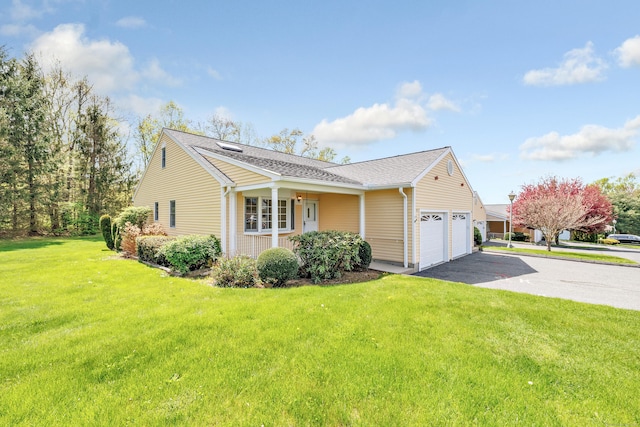 view of home's exterior featuring a porch, driveway, a yard, a garage, and a shingled roof