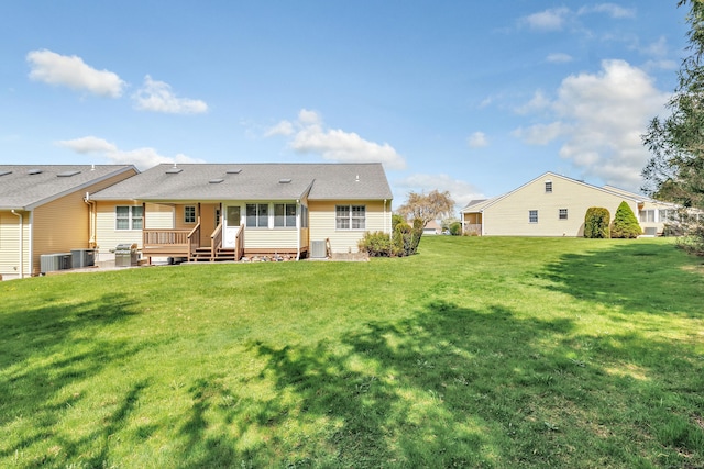 rear view of property with a yard, central AC, and a sunroom