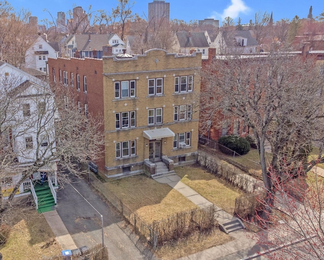 view of building exterior featuring a residential view, fence, and entry steps