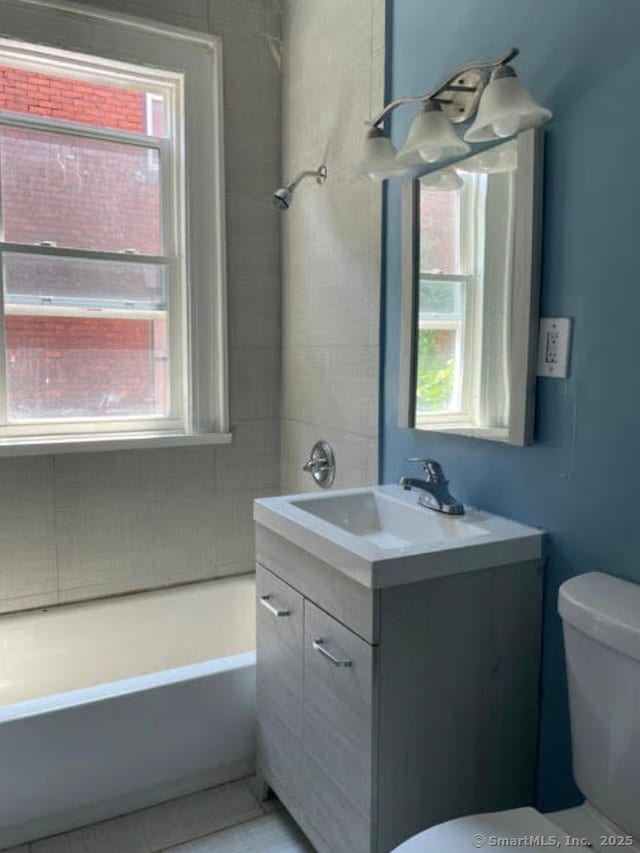 full bath featuring toilet, tile patterned flooring, vanity, and a bathtub