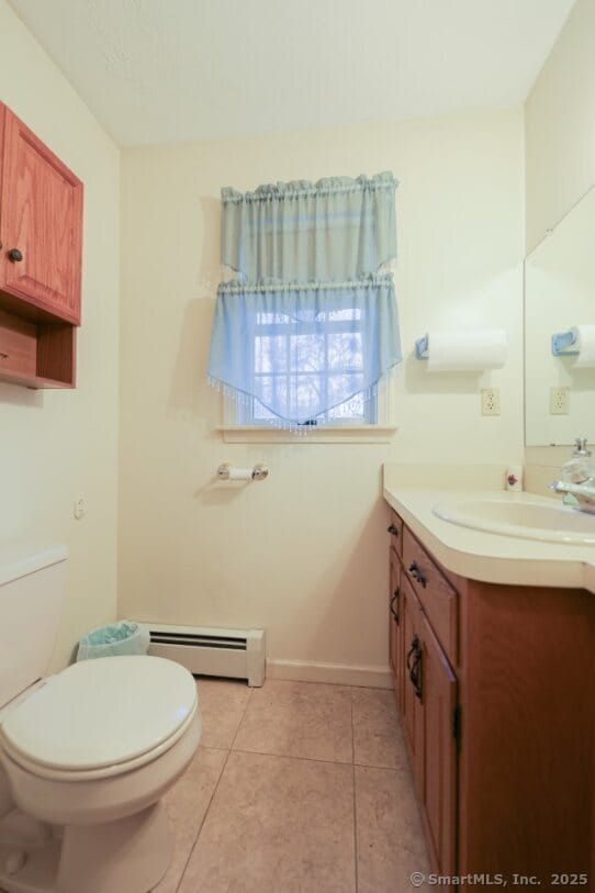 1900 Litchfield Rd, Watertown, CT 06795 - half bath featuring baseboard heating, toilet, vanity, and tile patterned flooring