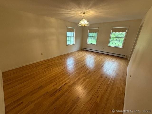 1900 Litchfield Rd, Watertown, CT 06795 - unfurnished room featuring a baseboard radiator, plenty of natural light, a chandelier, and wood finished floors