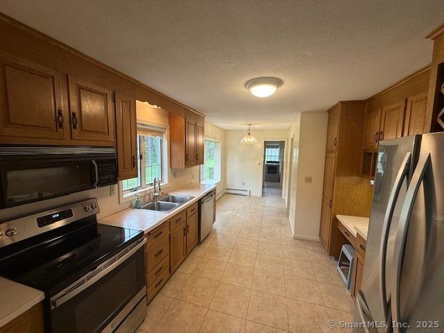 1900 Litchfield Rd, Watertown, CT 06795 - kitchen featuring appliances with stainless steel finishes, a sink, brown cabinets, light countertops, and a textured ceiling