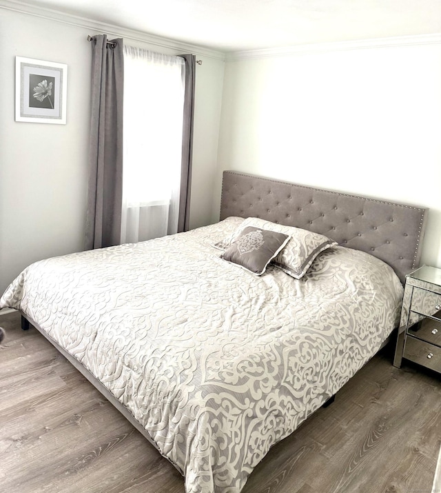 bedroom featuring crown molding and wood finished floors