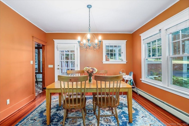 dining room with crown molding, baseboards, a baseboard radiator, a notable chandelier, and wood finished floors