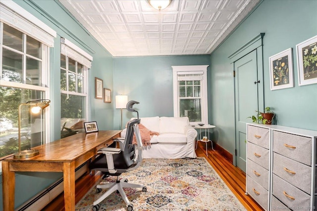 home office with wood finished floors, an ornate ceiling, and baseboard heating
